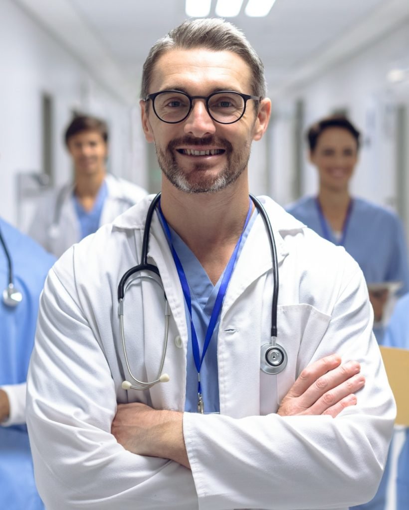 diverse medical team of doctors looking at camera while holding clipboard and medical files